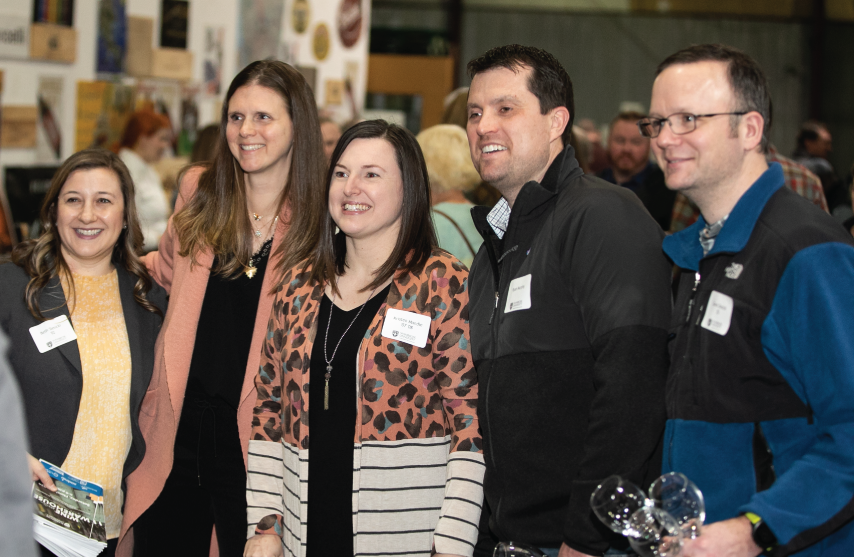 A group of people gathered at the wine festival smiling together.