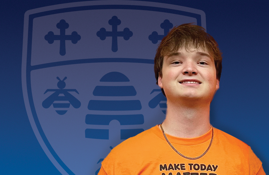 Carson Dalaska stands against a blue SAU background and smiles at the camera.