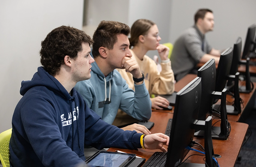 Students look intently a a row of mointors.