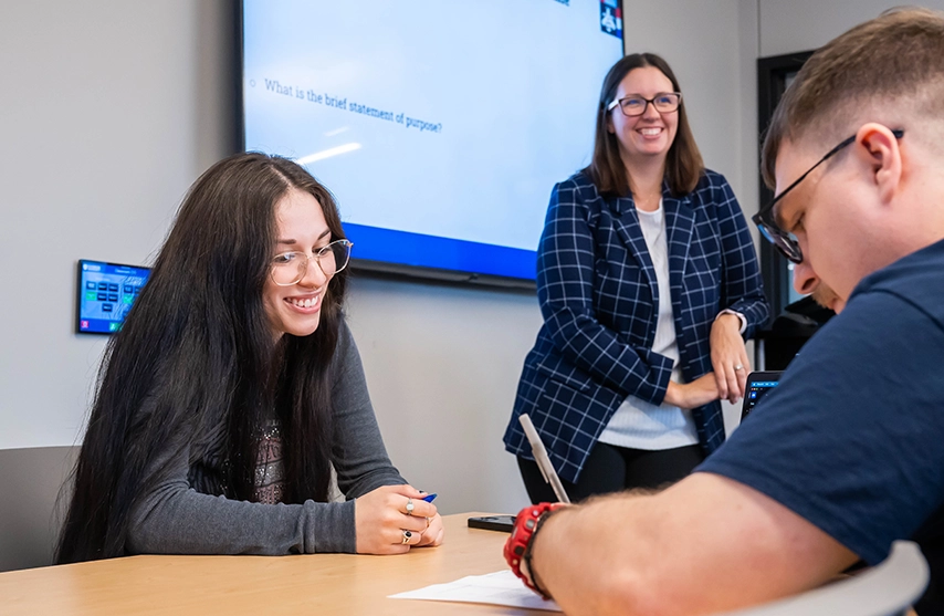 A St. Ambrose University instructor stands by as two Bachelor of Social Work students work together during a class.