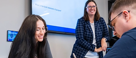 A St. Ambrose University instructor stands by as two Bachelor of Social Work students work together during a class.