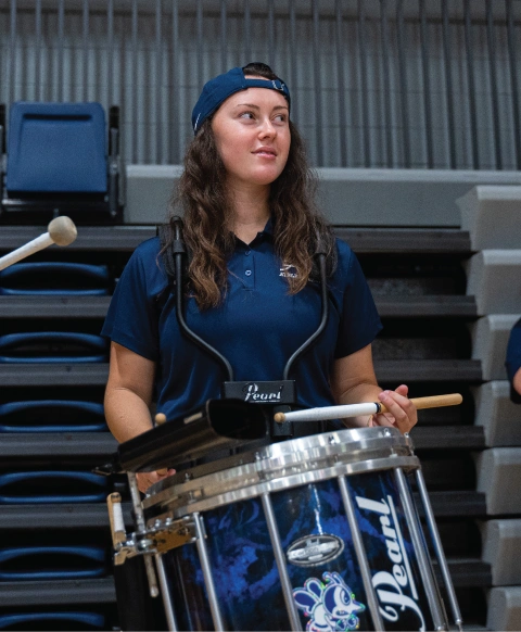 Student playing drums indoors.