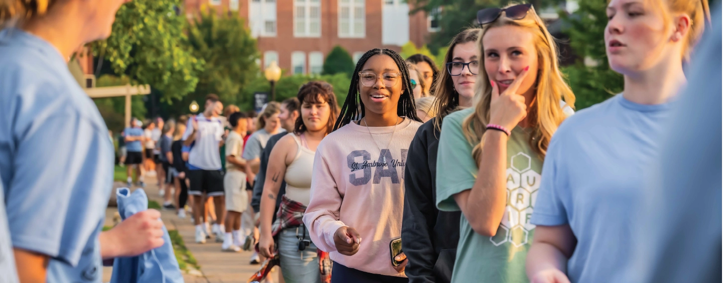 Group of students in line outdoors, smiling.