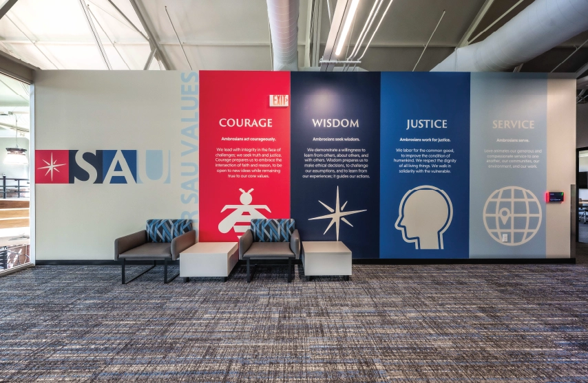 A wall in Higgins Hall with images representing SAU's values of courage, wisdom, justice and service.
