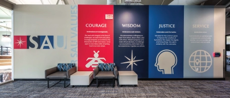 Una pared en Higgins Hall con imágenes que representan los valores de coraje, sabiduría, justicia y servicio de SAU.